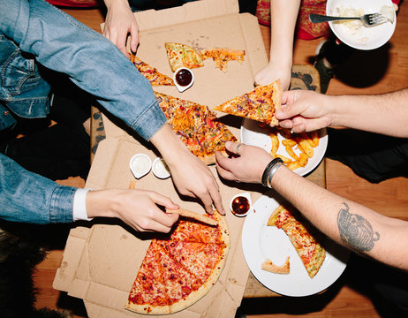 Anonymous people eating pizza