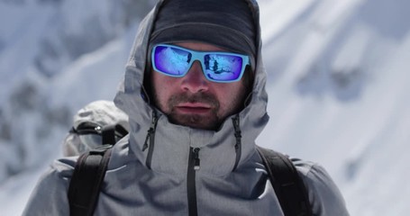 Climber mountaineer man portrait on snowy mount top in sunny day.Mountaineering ski activity. Skier people winter snow sport in alpine mountain outdoor.Front view.Slow motion 60p 4k video