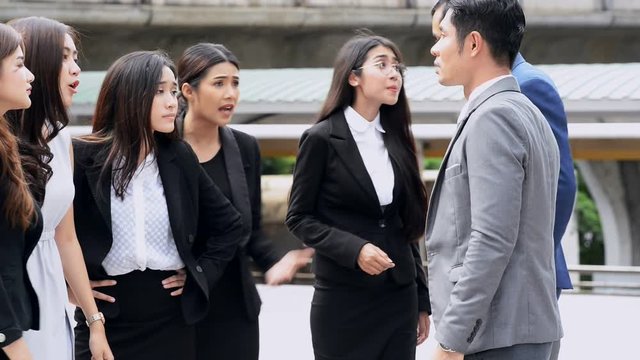 Business team having huge argument. Young chinese business man and woman having a violent argument in public.