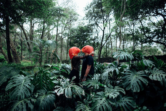 couple with orange fish masks on a rainforest