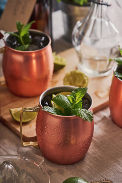 Moscow mule cocktails in copper mugs on a table.