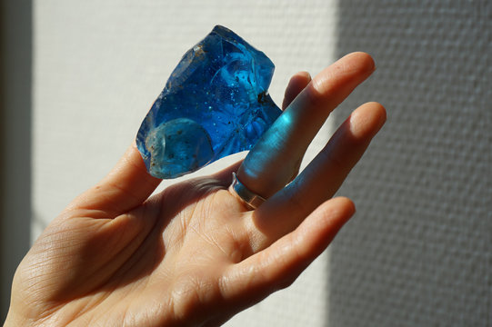 Woman holding bright blue obsidian