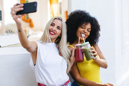 Girlfriends Taking A Selfie Showing Her Fresh Smoothies.