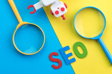 SEO Search engine optimization concept with blue and yellow magnifying glass, alphabet abbreviation...