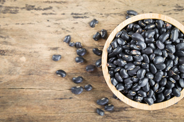 Black beans in wooden bowl. Top view.