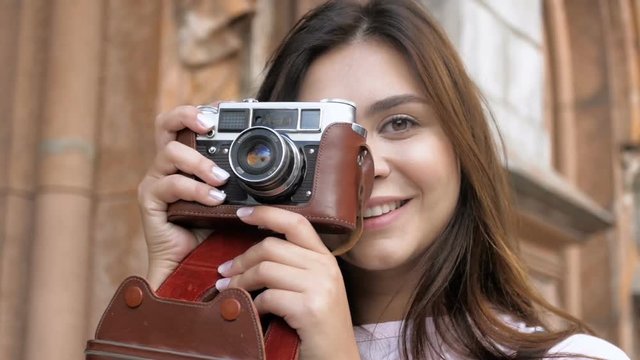 Closeup slow motion video of smiling tourist girl pressing shutter button on vintage film camera