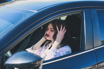 Troubled woman sitting in car
