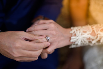 The groom is wearing a bridal ring.