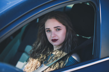 Fototapeta na wymiar Young woman in car looking at camera