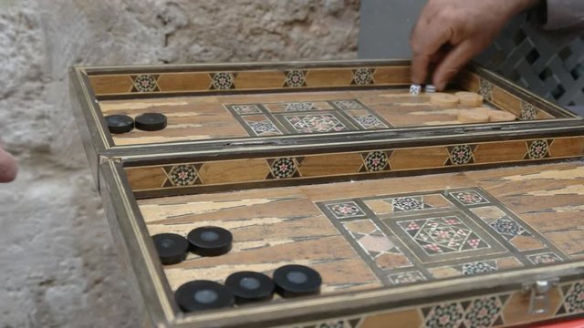close up of two men playing a game of arabic backgammon in the muslim quarter of the old city, jerusalem
