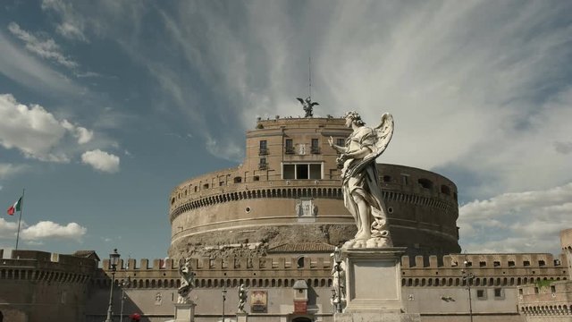 low angle shot of an angel statue on bridge with castel santangelo, rome in the background