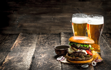 Street food. A big burger with glasses of light beer.