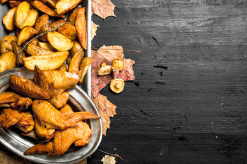 Smoked chicken wings with fried potatoes.