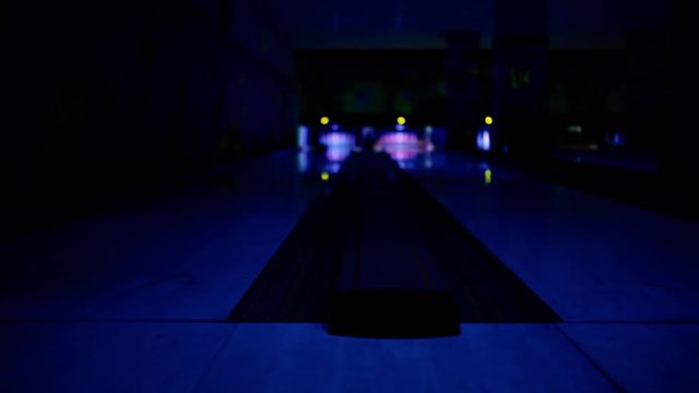 In the game club for bowling, players on two paths throw balls on the pins. Shallow depth of abrasion. focus on the foreground.
