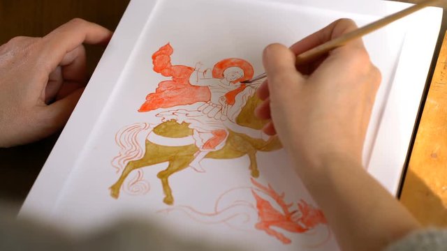woman painter paints a religious icon