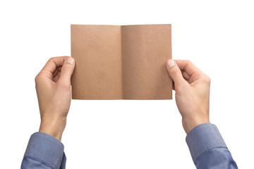 Mockup empty blank kraft postcard bent in half holds the man in his hand in shirt. Isolated on a white background