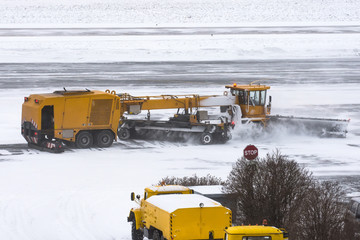 Large snow plowing machine at work on the road during a snow storm in winter.