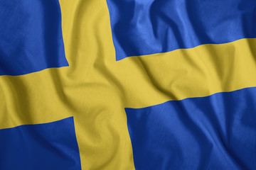 The Swedish flag is flying in the wind. Colorful national flag of Sweden. Patriotism, patriotic symbol.