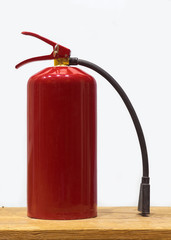 Red fire extinguisher on wooden table