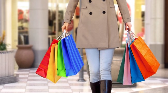 Women walking in a mall with handfull of shopping bags