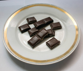 chocolate bars with nuts on a white saucer