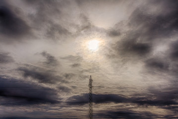 Obraz premium Torre eléctrica de alta tensión y cielo cubierto de nubes en invierno. 