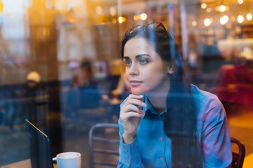 young girl in shirt sitting and drinking coffee