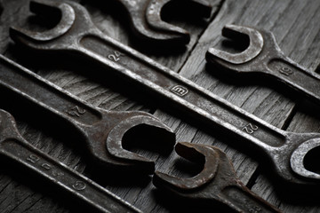 Fototapeta premium Dirty set of hand tools on a wooden background. Old rusty tools Sales tools for assembly workers. Old shop Old working. Vintage working tools (drill, saw, ruler and others) on wooden background