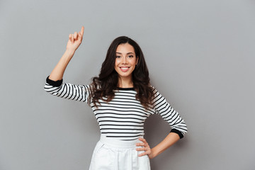 Portrait of a smiling woman pointing finger up