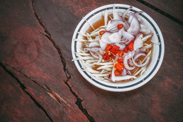 Sweet and Sour Sauce with mango,onion sliced and red sliced chilli on the red broken table