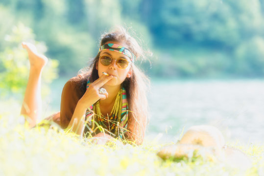 Pretty free hippie girl smoking on the grass - Vintage photo effect