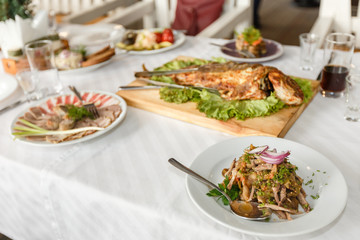 Fried fish and dishes on a banquet table in a restaurant