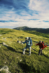 Obraz premium Summer hike in the mountains with a backpack and tent.