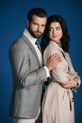 boyfriend hugging girlfriend isolated on blue