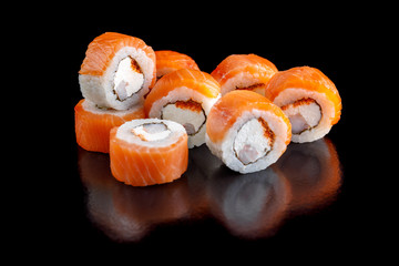 Original set of sushi with salmon, shrimp and Philadelphia cheese on a black background close-up.