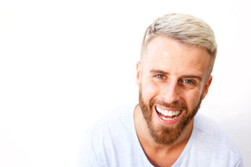 Close up young man with beard laughing against white background