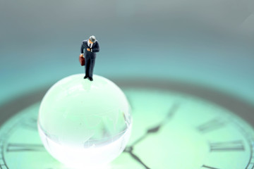 Miniature people : business man looking at watch and walk on the clock background, time business...
