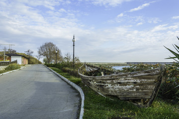Fototapeta na wymiar Wreck boat in the side of the road