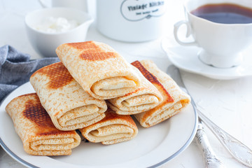 Stuffed with meat fried pancakes on a traditional carnival on a white table, horizontal