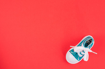 One new green gym shoes on red paper. Top view