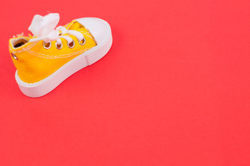 One new yellow gym shoes on red paper