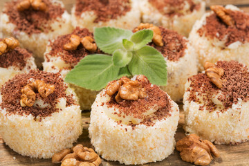 a lot of cakes lined on a wooden table, dessert with walnuts