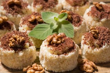 a lot of cakes lined on a wooden table, dessert with walnuts