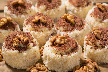 a lot of cakes lined on a wooden table, dessert with walnuts