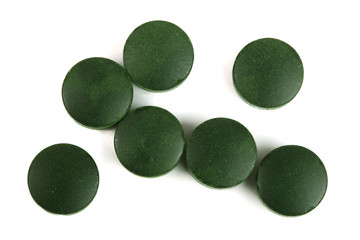 Spirulina tablets algae nutritional supplement isolated on white background close up top view. Flat lay