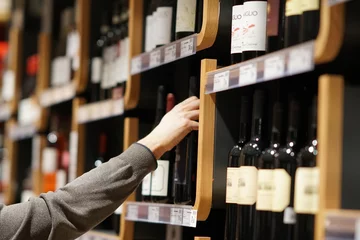 Cercles muraux Bar Choisir une bouteille de vin en supermarché