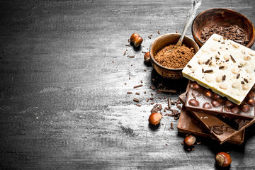 Bars of different types of chocolate with cocoa powder.