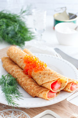 Pancakes with red caviar on plate. Russian cuisine. Maslenitsa