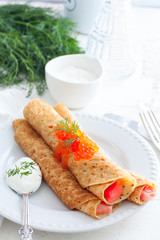 Pancakes with red caviar on plate. Russian cuisine. Maslenitsa