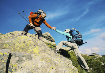 Couple Man and Woman help giving hands climbing rocky mountains Love and Travel Lifestyle concept...